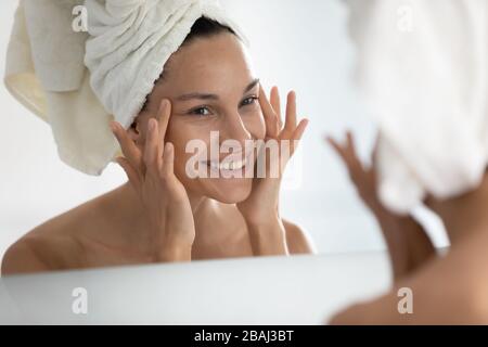 Dopo la procedura domestica di bellezza la donna che guarda la pelle ritiene soddisfatta Foto Stock