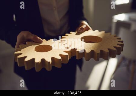 Il raccolto di gente di affari che accatastano le ruote dentate nel team Foto Stock