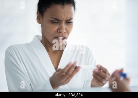 Donna africana vedere il risultato positivo sul test di gravidanza si sente scioccato Foto Stock