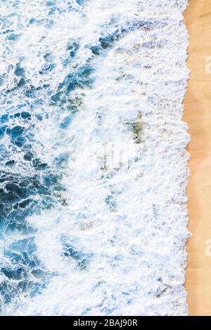 Vista dall'alto, splendida vista aerea delle onde che si infrangono su una splendida spiaggia durante una giornata di sole. Spiaggia di Nyang Nyang, Bali sud, Indonersia Foto Stock