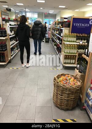 Toronto, Canada. 27 marzo 2020. Gli acquirenti attendono il check-out presso un negozio LCBO, la catena di liquori a gestione governativa provinciale, a Toronto, Canada, il 27 marzo 2020. PER ANDARE CON 'feature: Torontoniani mantenere la calma in nuova normalità durante COVID-19' Credit: Sun Huixia/Xinhua/Alamy Live News Foto Stock