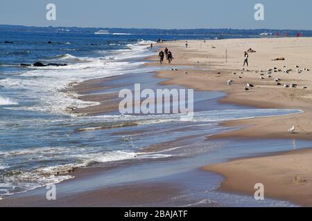 Coney Island, New York, USA-settembre 2019; lunga vista della tranquillità fuori stagione sulla spiaggia di Coney Island con persone che godono del tempo e. Foto Stock