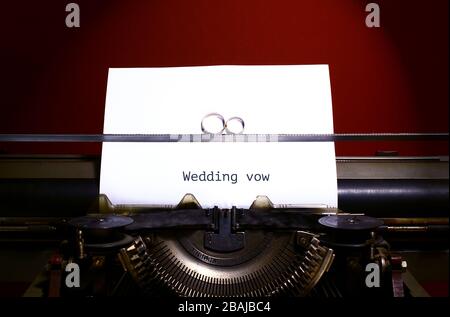 Due anelli di nozze in segno infinito su una macchina da scrivere. Concetto di voto per matrimoni. Foto Stock