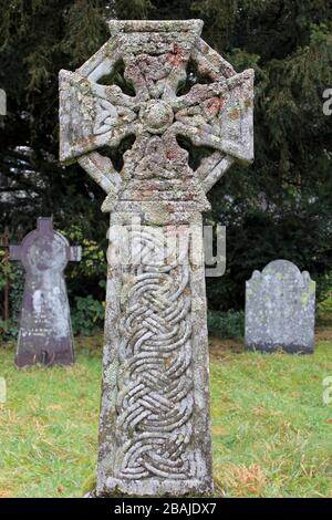 Croce decorata con trifoglio e nodi celtici e coperto di licheni, cimitero della vecchia chiesa di San Michele, Betws Y Coed, Conwy Valley, Galles Foto Stock