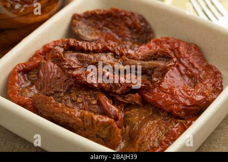 Ciotola con pomodori secchi italiani in olio d'oliva primo piano Foto Stock