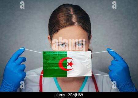 Coronavirus in Algeria Donna Dottore Ritratto Hold proteggere viso maschera chirurgica con Algeria Bandiera Nazionale. Malattia, virus Covid-19 in Algeria, Foto Stock