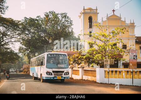 Goa, India - 14 febbraio 2020: Autobus che si muove sullo sfondo Santa Croce Chiesa in Sunny Day Foto Stock