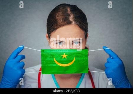 Coronavirus in Mauritania Donna medico ritratto tenere proteggere viso maschera chirurgica medico con Mauritania Bandiera Nazionale. Malattia, virus Covid-19 a Mau Foto Stock