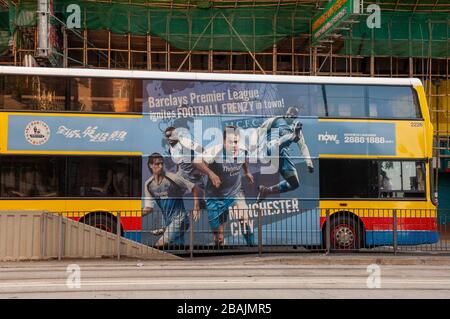 Trasporto pubblico di Hong Kong con un autobus che mostra i giocatori di Manchester City nelle loro magliette blu cielo. Foto Stock
