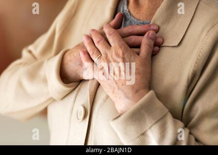 Donna anziana che soffre di dolore toracico Foto Stock