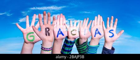 Molti bambini mani costruire Parola Gracias significa grazie, cielo blu Foto Stock