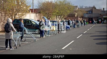 Piershill, Edimburgo, Scozia, Regno Unito. 28 Marzo 2020. La coda di distanziamento di Coronavirus Social intorno al parcheggio del supermercato Morrison, a Edimburgo. Dove il personale sta monitorando la quantità di clienti nello store in qualsiasi momento. Foto Stock