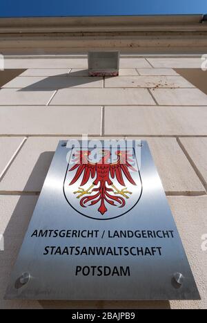 Potsdam, Germania. 25 Marzo 2020. L'insegna metallica accanto all'ingresso del Centro di Giustizia con l'Aquila Rossa come stemma nazionale e il riferimento al tribunale locale, al tribunale distrettuale e alla pubblica accusa. Credit: Soeren Stache/dpa-Zentralbild/ZB/dpa/Alamy Live News Foto Stock