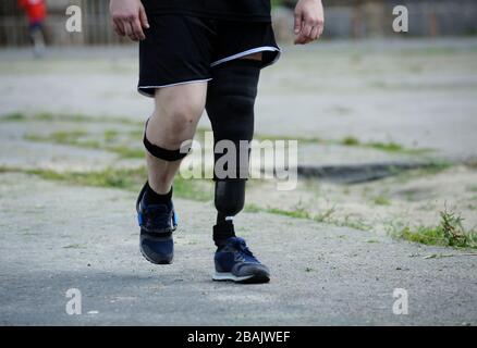 Corridore per disabili con una gamba artificiale che cammina sullo stadio Foto Stock