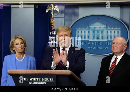 Il presidente degli Stati Uniti Donald J. Trump parla tra il segretario americano all’istruzione Betsy DeVos, sinistra, E il Segretario dell'Agricoltura degli Stati Uniti Sonny Perdue e il Segretario dell'Agricoltura Sonny Perdue durante un briefing stampa sulla pandemia Coronavirus COVID-19 con i membri della Task Force Coronavirus alla Casa Bianca di Washington, DC, il 27 marzo 2020. Credito: Yuri Gripas/Pool via CNP/MediaPunch Foto Stock