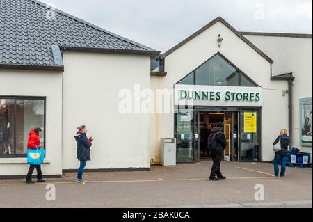 Clonakilty, West Cork, Irlanda. 28 Marzo 2020. Nonostante un Taoiseach, Leo Varadkar, che diceva che la popolazione irlandese dovrebbe rimanere a casa per tutti i viaggi, ma essenziali, a causa di Covid-19, c'era una grande coda fuori dai negozi Dunnes a Clonakilty oggi. La maggior parte degli acquirenti ha atteso 20-30 minuti per entrare nel negozio per il loro negozio settimanale. La direzione di Dunnes Stores ha affermato che solo 75 persone sono state autorizzate a entrare nello shop contemporaneamente e che i clienti si attendevano alle linee guida per le distanze sociali. Credit: Notizie dal vivo di AG/Alamy Foto Stock