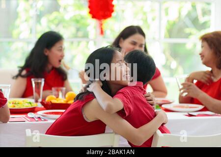 Capodanno cinese. La famiglia celebra la vacanza invernale. Cena tradizionale festiva in Cina. Genitori, nonni e bambini che mangiano e danno Foto Stock