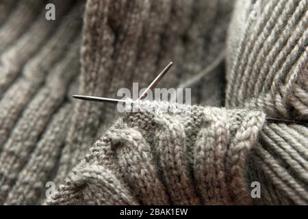 Aghi da maglieria vintage e filato grigio su sfondo sciarpa - maglia di lana naturale sfondo. home hobby concetto - cosa fare a casa. Tempo libero Foto Stock