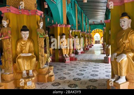 Una sala con Buddha colorati d'oro nel Monastero di Kyaw Aung San Dar, Amarapura, Myanmar Foto Stock