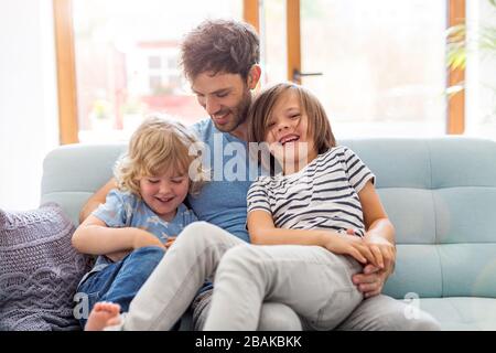 Padre a giocare con i suoi figli a casa Foto Stock