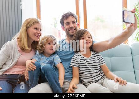 Felice giovane famiglia con due figli a casa Foto Stock
