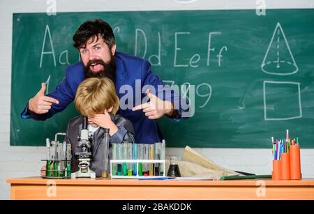 Torna alla classe è fresco. Al microscopio in laboratorio. Torna a scuola. Insegnante uomo con ragazzino. Attrezzatura da scuola. Studente che fa esperimenti scientifici con microscopio in laboratorio. padre e figlio a scuola. Foto Stock