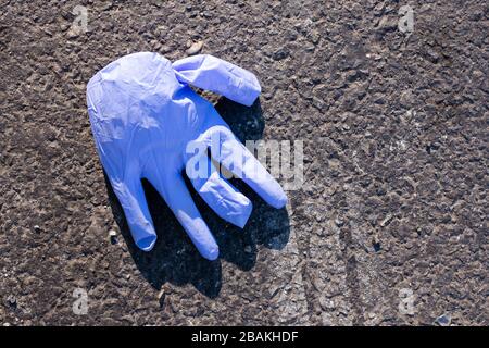 Brooklyn, NY - 27 marzo 2020. Le restrizioni al pubblico durante la pandemia COVID-19 hanno causato la carenza di maschere chirurgiche e guanti. Nonostante la scarsità, entrambi sono spesso scartati, e possono essere trovati sulle strade e marciapiedi della città. Foto Stock