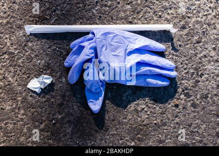 Brooklyn, NY - 27 marzo 2020. Le restrizioni al pubblico durante la pandemia COVID-19 hanno causato la carenza di maschere chirurgiche e guanti. Nonostante la scarsità, entrambi sono spesso scartati, e possono essere trovati sulle strade e marciapiedi della città. Foto Stock