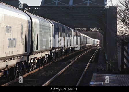 Lungo treno di carri ferroviari Drax Biomass che attraversano il ponte di King George V ad Althorpe Lincolnshire trainato da una locomotiva DBC cargo UK classe 66 Foto Stock