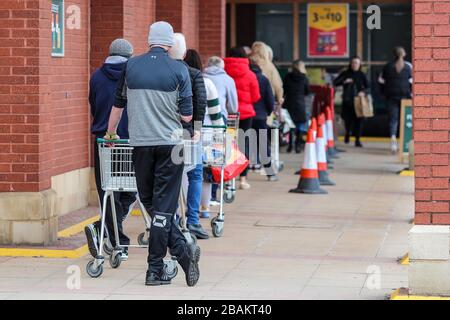 Ayr, Regno Unito. 28 Marzo 2020. In conformità con le istruzioni del governo, la maggior parte della gente rimane lontano dai centri commerciali e dalle strade normalmente popolari e trafficate di Ayr lasciando un centro cittadino quasi vuoto tranne alcuni rivenditori e farmacie del cibo. Il cliente si trova in una fila ordinata, a 2 metri di distanza, in attesa di essere autorizzato a fare acquisti al supermercato Morrison, Ayr. Credit: Findlay/Alamy Live News Foto Stock