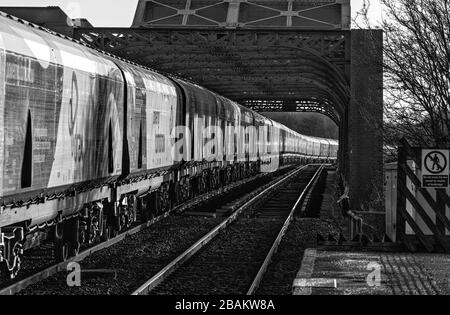 Lungo treno di carri ferroviari Drax Biomass che attraversano il ponte di King George V ad Althorpe, Lincolnshire Foto Stock