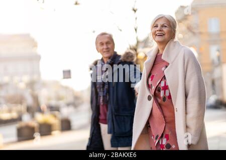 Coppia senior a piedi sulla strada della città durante il giorno invernale Foto Stock