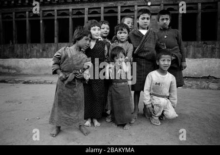 I bambini di argenteria sono curiosi e timidi con uno straniero, vicino a Densholing, Bhutan, Foto Stock