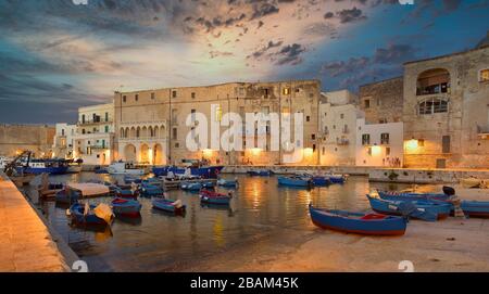 Barche da pesca nella baia di Monipoli con cielo nuvoloso, Italia meridionale, Europa Foto Stock