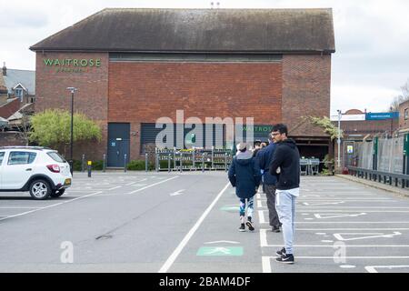 Londra, Regno Unito. 28 marzo 2020. I clienti fanno la fila nel parcheggio in attesa di entrare in un supermercato Waitrose & Partners a Northwood, a nord-ovest di Londra. La catena di supermercati ha implementato un sistema di accesso controllato nei suoi negozi che mantiene i clienti a 2 metri di distanza, limita le scorte e garantisce che le scorte sugli scaffali rimangano disponibili per tutti i clienti. Il Dipartimento della Salute ha annunciato che finora nel Regno Unito sono morte 1,019 persone a causa del coronavirus, con 17,089 casi confermati e 103,687 persone con test negativi per il virus. Credit: Stephen Chung / Alamy Live News Foto Stock