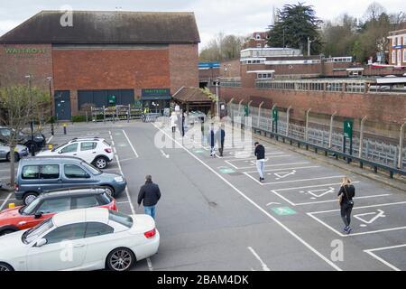 Londra, Regno Unito. 28 marzo 2020. I clienti fanno la fila nel parcheggio in attesa di entrare in un supermercato Waitrose & Partners a Northwood, a nord-ovest di Londra. La catena di supermercati ha implementato un sistema di accesso controllato nei suoi negozi che mantiene i clienti a 2 metri di distanza, limita le scorte e garantisce che le scorte sugli scaffali rimangano disponibili per tutti i clienti. Il Dipartimento della Salute ha annunciato che finora nel Regno Unito sono morte 1,019 persone a causa del coronavirus, con 17,089 casi confermati e 103,687 persone con test negativi per il virus. Credit: Stephen Chung / Alamy Live News Foto Stock