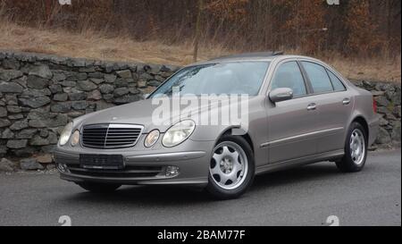 Mercedes-Benz Classe e isolata - alias W211, colore metallizzato oro, ornamenti cromati, finestre azzurre,anno 2004,angolo posteriore sinistro, tronco,Avantgarde Foto Stock