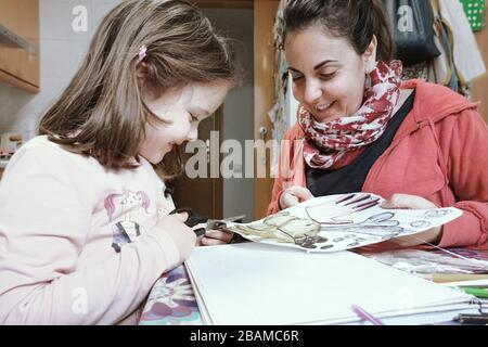Madre caucasica e figlia al confinamento di quarantena del coronavirus. Istruzione domestica e scolarizzazione covid-19 durante l'involucro con spazio vuoto della copia Foto Stock