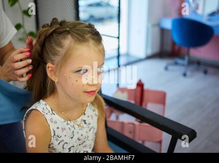 Servizi di parrucchiere. Pettinatura. Processo di styling dei capelli. Parrucchiere per bambini Foto Stock