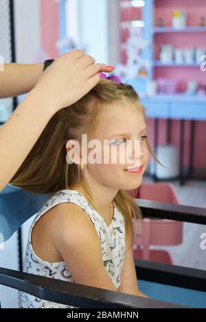 Servizi di parrucchiere. Pettinatura. Processo di styling dei capelli. Parrucchiere per bambini Foto Stock