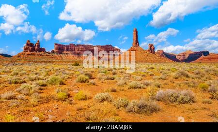 La pietra arenaria rossa Buttes e pinnacoli in semi paesaggio desertico nella Valle degli Dèi stato parco nei pressi di Mexican Hat, Utah, Stati Uniti Foto Stock