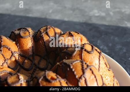 Una torta fatta in casa è illuminata dal sole. Mattina presto. Prima colazione: Forno fatto in casa con cioccolato Foto Stock