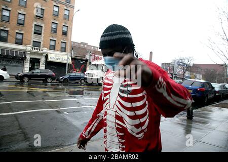 The Bronx, New York, NY, USA, 28th. Mar, 2020. Un newyorkese mette il proprio francobollo sulla protezione COVID-19 mentre è in viaggio su Prospect Avenue in the Sout Foto Stock