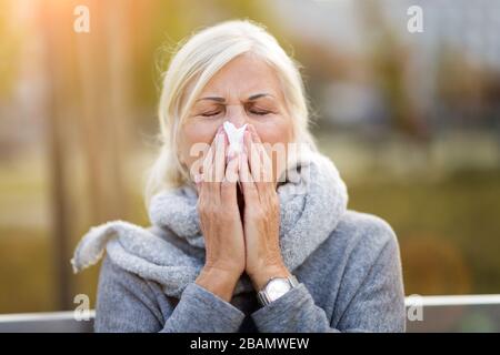 Donna anziana con un tessuto all'aperto Foto Stock