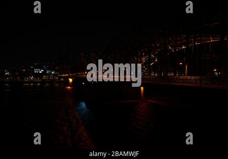 Colonia, Germania. 28 Marzo 2020. Dopo aver spento le luci della cattedrale e del ponte Hohenzollern, il centro della città è al buio. Durante la campagna mondiale Earth Hour dell'organizzazione ambientale WWF, le luci sugli edifici pubblici vengono spente per un'ora. Credit: Henning Kaiser/dpa/Alamy Live News Foto Stock