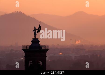 Statua in cima al campanile della Chiesa di Sant'Alessandro della Croce raffigurata contro l'alba, Bergamo, Italia Foto Stock