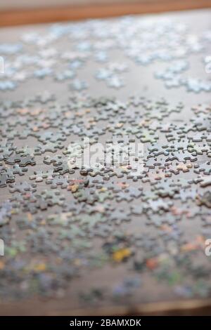 Pezzi di puzzle jigsaw su un piano di tavolo. Primo piano. Messa a fuoco stretta. Concettuale. Foto Stock