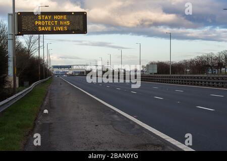 Glasgow, Regno Unito. 28 Marzo 2020. Nella foto: Segnaletica stradale lungo le autostrade M8 e M80 che recita: "STAY HOME PROTECT NHS SAVE LIVES" il Coronavirus Pandemic ha costretto il governo britannico a chiudere tutte le principali città del Regno Unito e a far sì che le persone restino a casa, che ha lasciato le autostrade e tutte le altre strade libere dal solito traffico naso a coda che altrimenti sarebbe lì. Credit: Colin Fisher/Alamy Live News Foto Stock