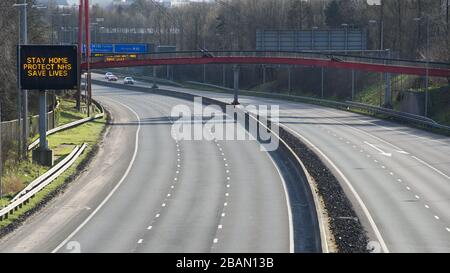 Glasgow, Regno Unito. 28 Marzo 2020. Nella foto: Segnaletica stradale lungo le autostrade M8 e M80 che recita: "STAY HOME PROTECT NHS SAVE LIVES" il Coronavirus Pandemic ha costretto il governo britannico a chiudere tutte le principali città del Regno Unito e a far sì che le persone restino a casa, che ha lasciato le autostrade e tutte le altre strade libere dal solito traffico naso a coda che altrimenti sarebbe lì. Credit: Colin Fisher/Alamy Live News Foto Stock