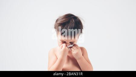 studio immagine da un bambino con fazzoletto. Il bambino malato isolato ha naso che cola. Foto Stock